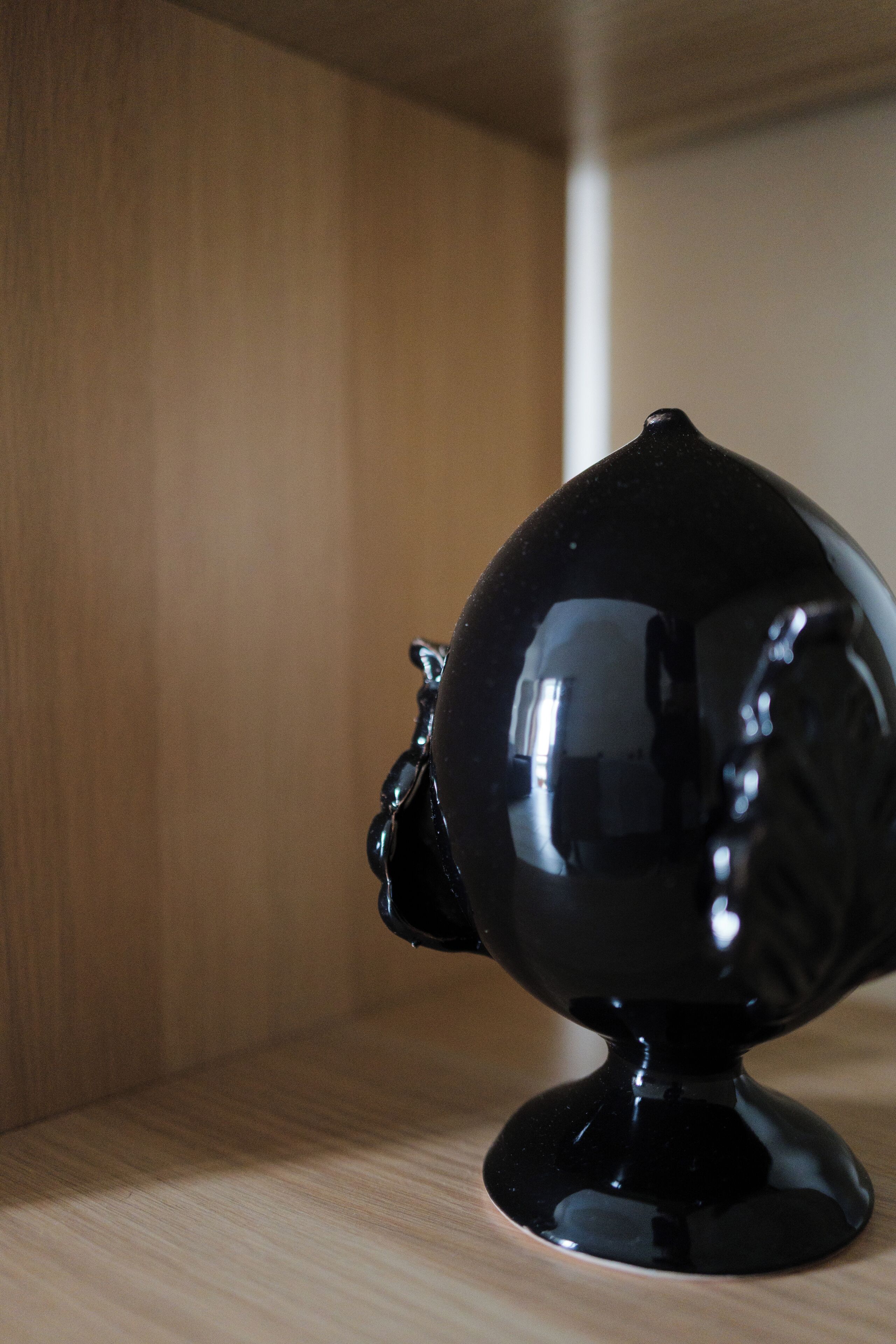 A black spherical object on a wooden surface.