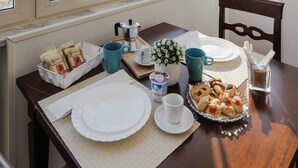 Una mesa de desayuno con platos, tazas y pasteles, con vista a un edificio histórico.