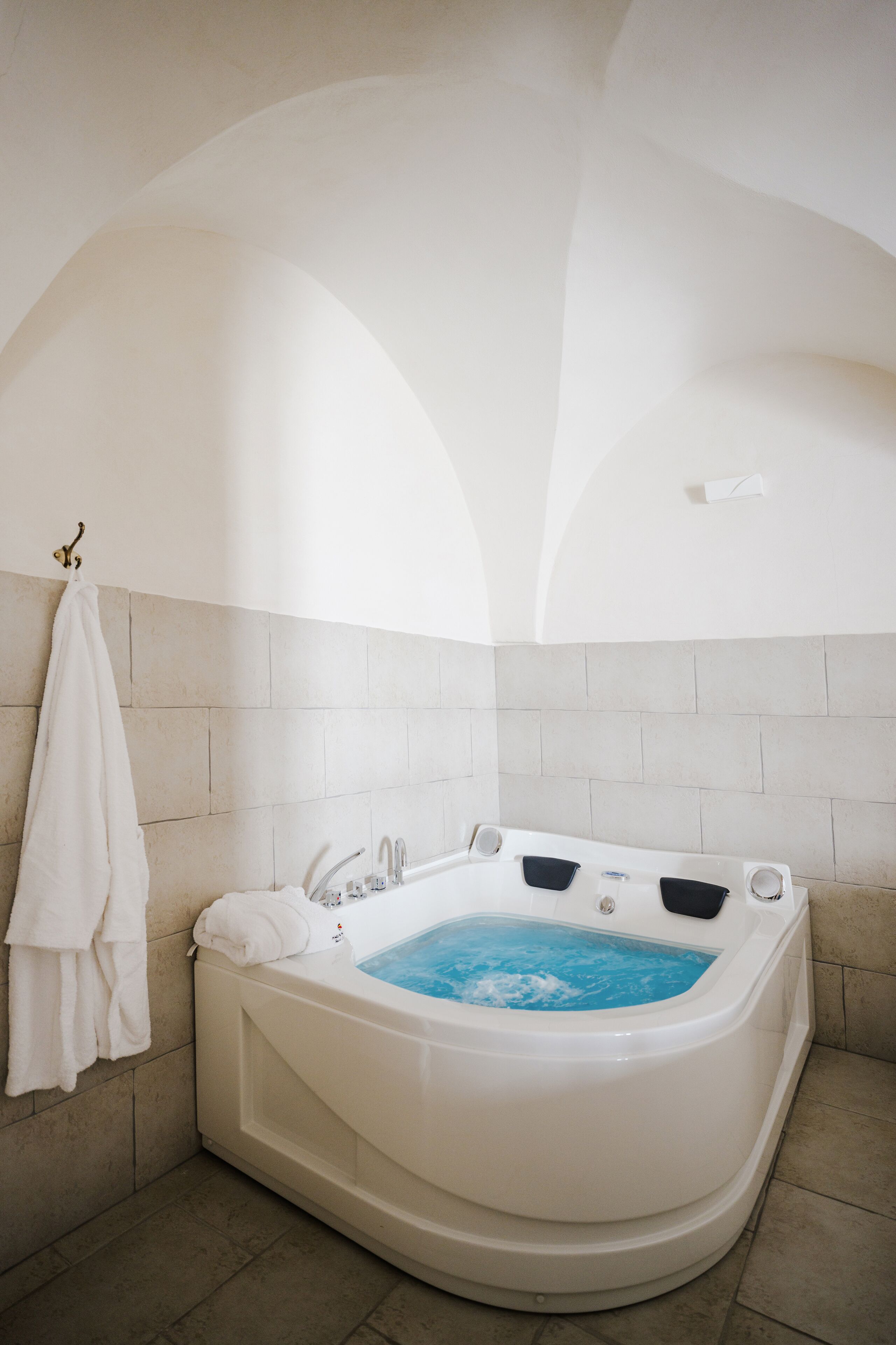 A modern bathroom with a freestanding bathtub, a towel rack, and a tiled floor.