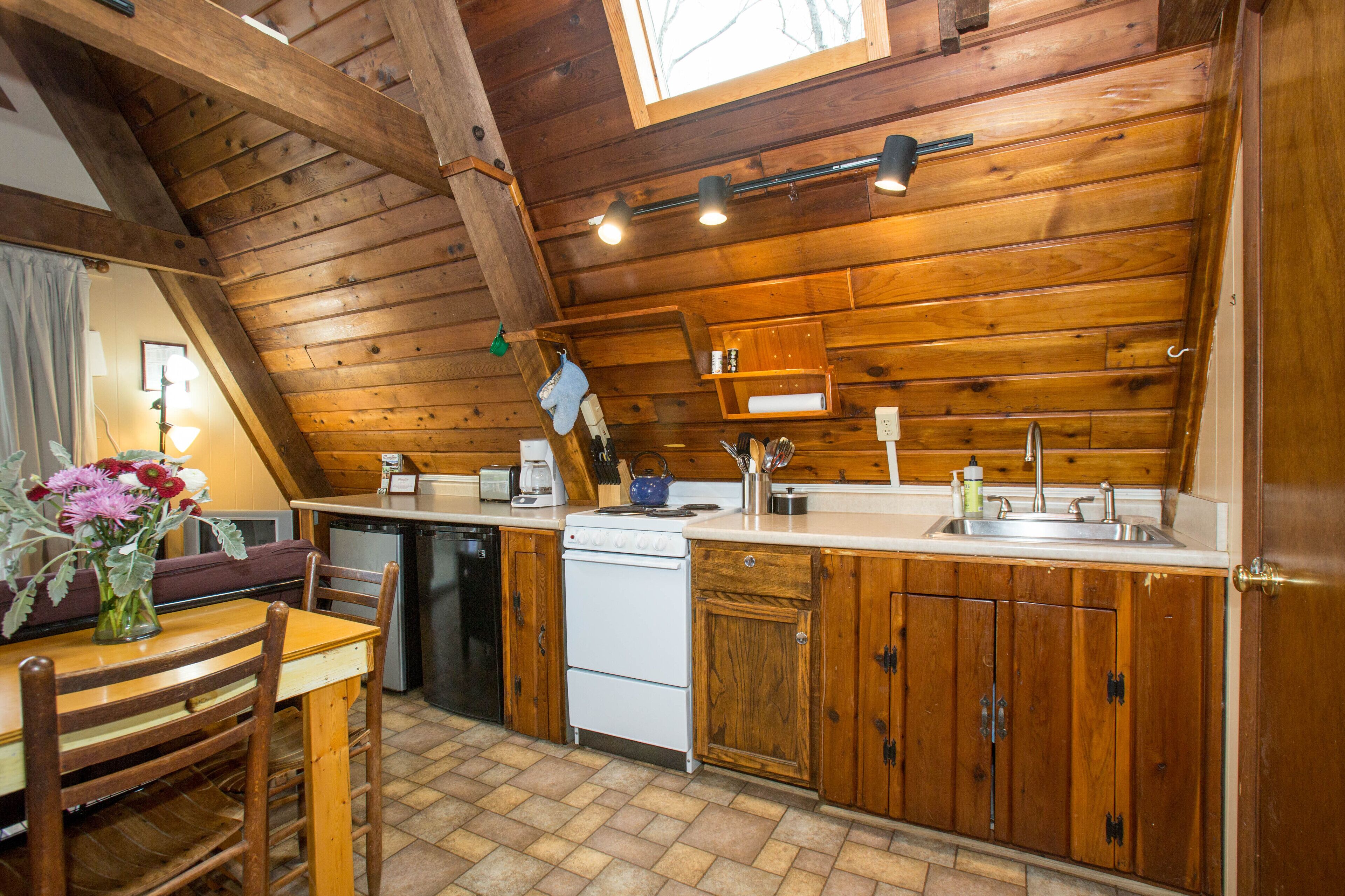A kitchen with wooden cabinets, a stove, and a sink.