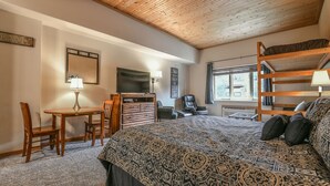 A bedroom with a bunk bed, a desk with a chair, a lamp, and a mirror on the wall. - Gateway Lodge 5002 by SummitCove Vacation Lodging (Keystone)
