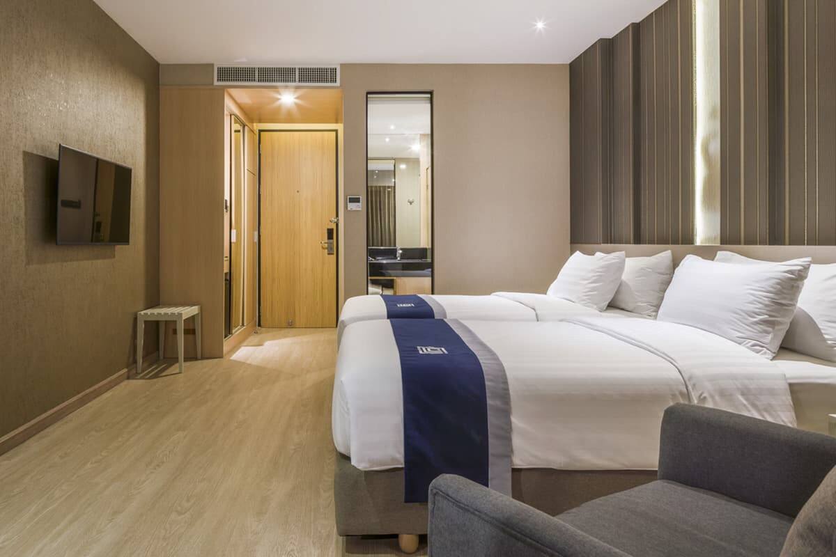 Een hotelkamer met een groot bed, een bureau, een stoel en een spiegel.