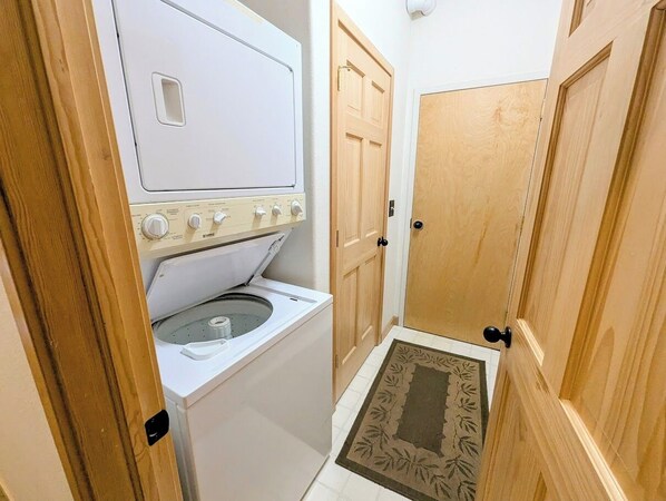 A laundry room with a washing machine and dryer, wooden doors, and a mat at the entrance. - Snake River 42 (Keystone)