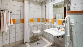 A modern bathroom with a shower, sink, and toilet.