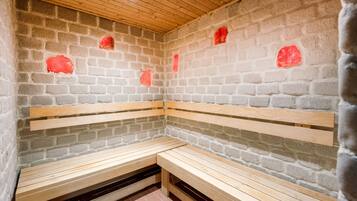 A sauna with wooden benches and brick walls.