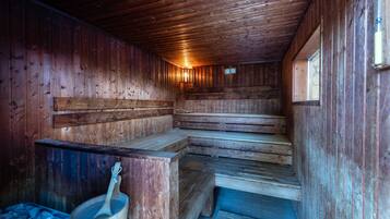 A wooden sauna with benches and a wooden bucket.