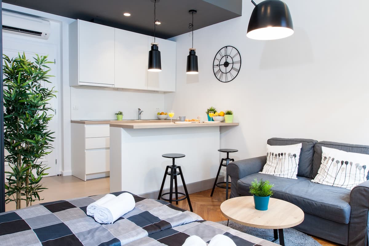 Un espace de vie moderne et compact, comprenant un coin cuisine, un espace repas et un canapé.