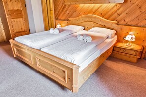 A double wooden bed with white linens and two bedside tables with lamps. - Hotel Bernina Hospiz - Hostel (Poschiavo)