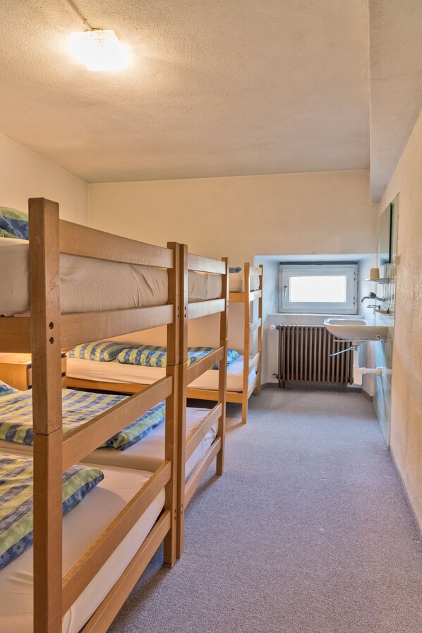 A dormitory room with bunk beds, a window, a radiator, and a sink. - Hotel Bernina Hospiz - Hostel (Poschiavo)