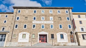 Un bâtiment en pierre portant l’inscription « Ospizio Bernina » et doté d’une porte rouge.