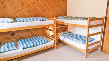 A bunk bed room with wooden walls and a carpeted floor.