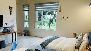Une chambre avec deux lits, un bureau et une vue sur l’extérieur.