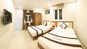 A hotel room with two beds, a TV, a wardrobe, and a window. - New Sky Hotel (Da Nang)