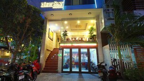 A hotel with a prominent 'New Sky Hotel' sign, a modern facade, and a welcoming entrance with a staircase leading to the lobby. - New Sky Hotel (Da Nang)