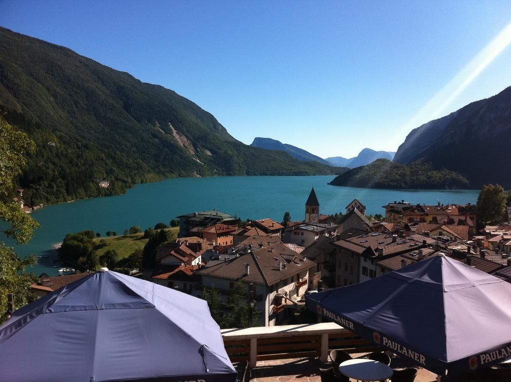 A lakeside town with a view of a lake and mountains.