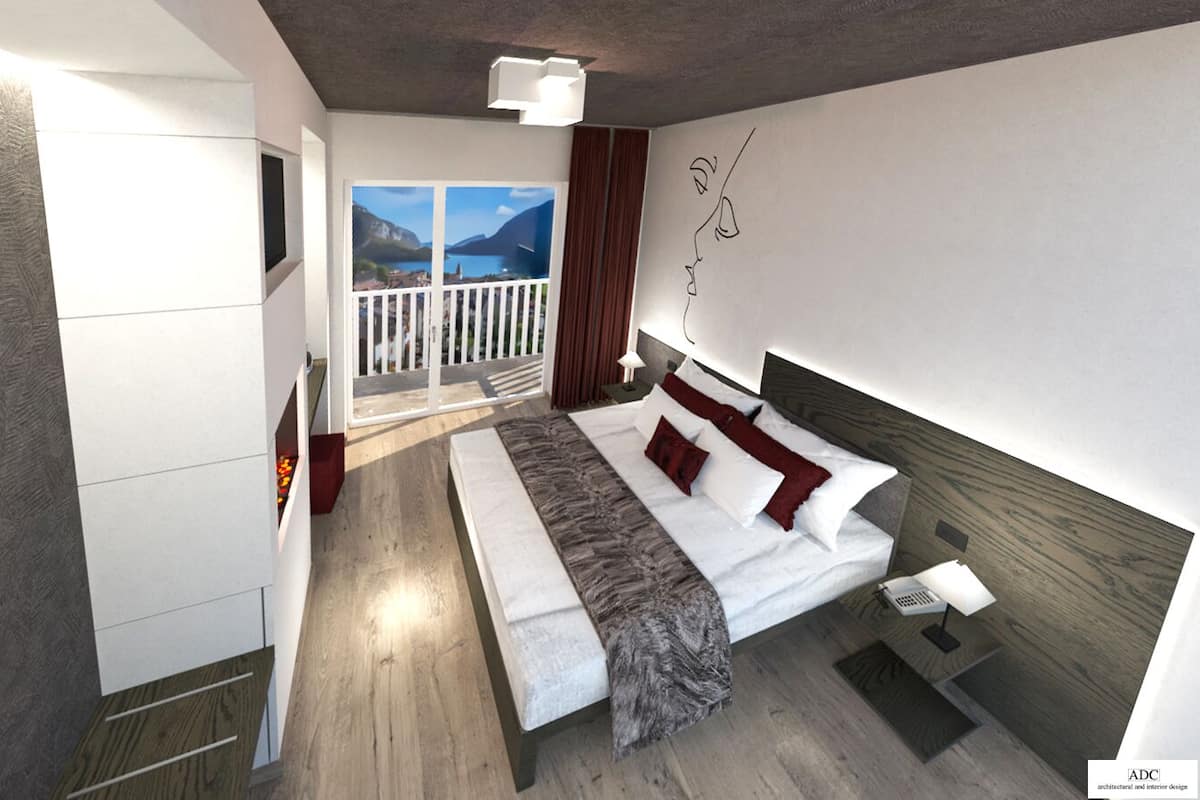 A modern bedroom with a large bed, a nightstand, a TV, and a balcony with a scenic view.
