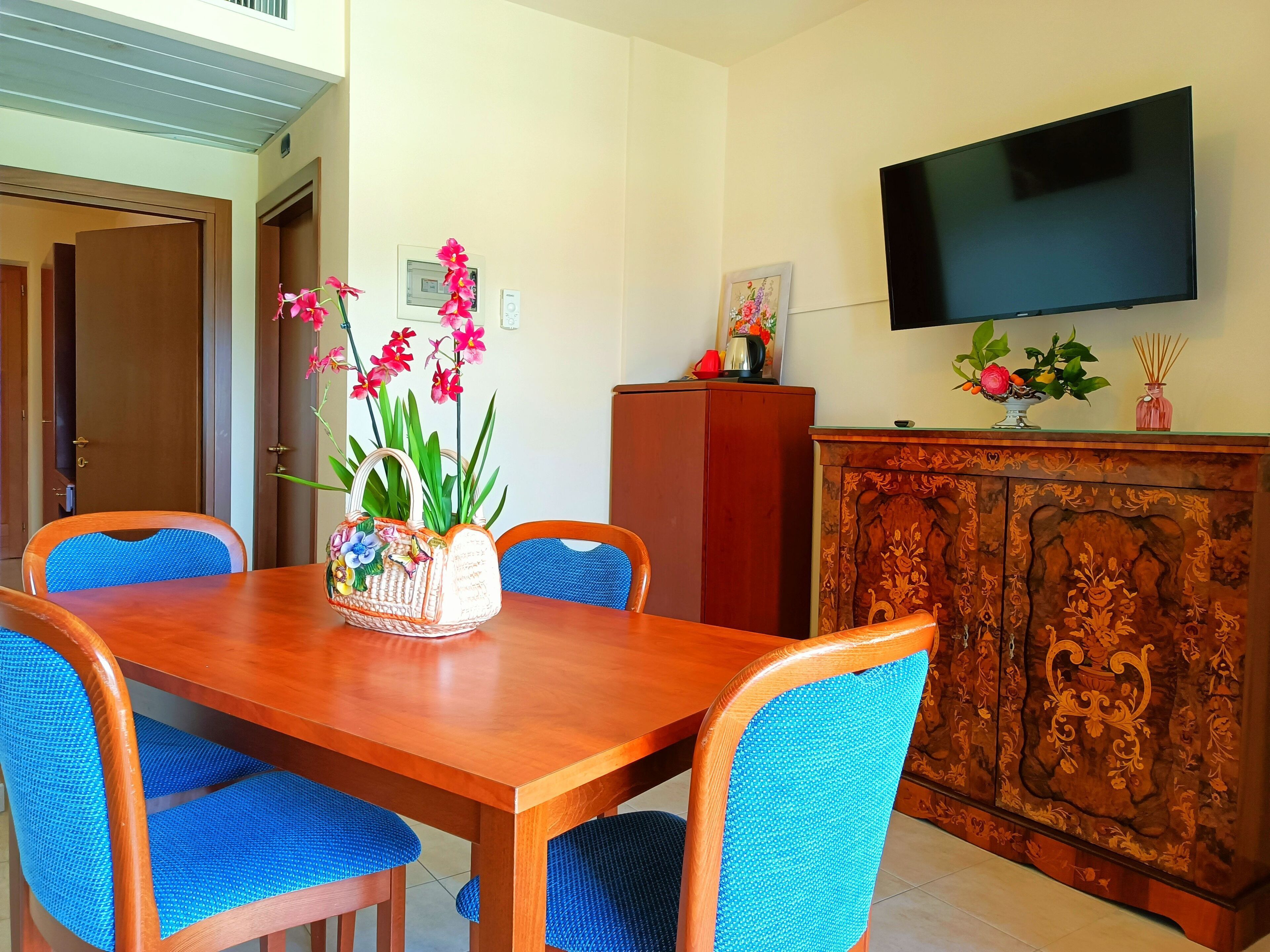 A dining area with a wooden table and blue upholstered chairs.