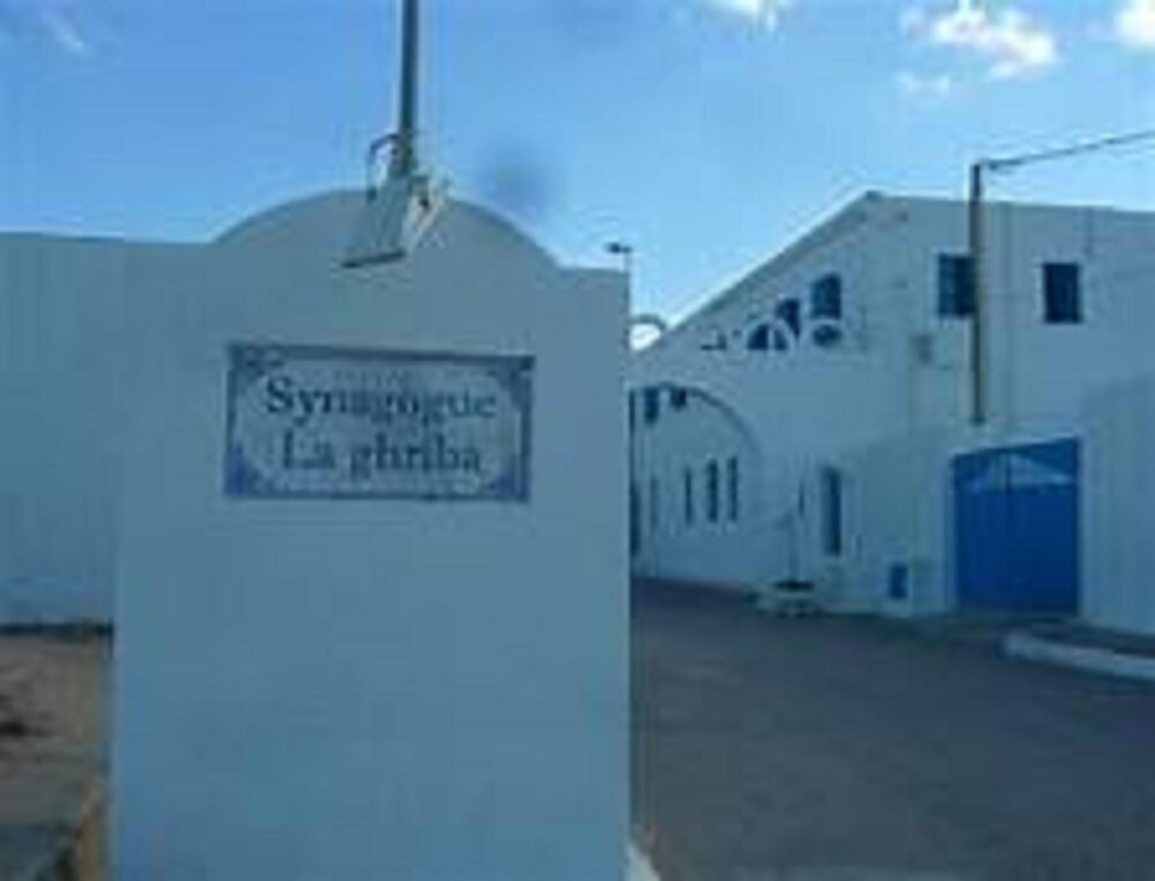 Un edificio con un letrero que dice "Syrnagogue La Ghriba".