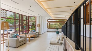 Un vestíbulo amplio con techo alto, ventanas grandes y una escalera moderna.