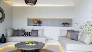 Een moderne woonkamer met een zithoek, een salontafel en decoratieve objecten.
