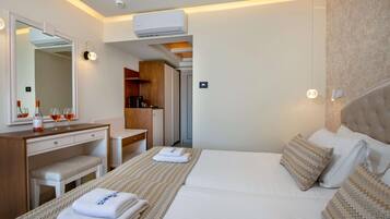 Quarto de hotel com cama, escrivaninha, cadeira, espelho e ar condicionado.