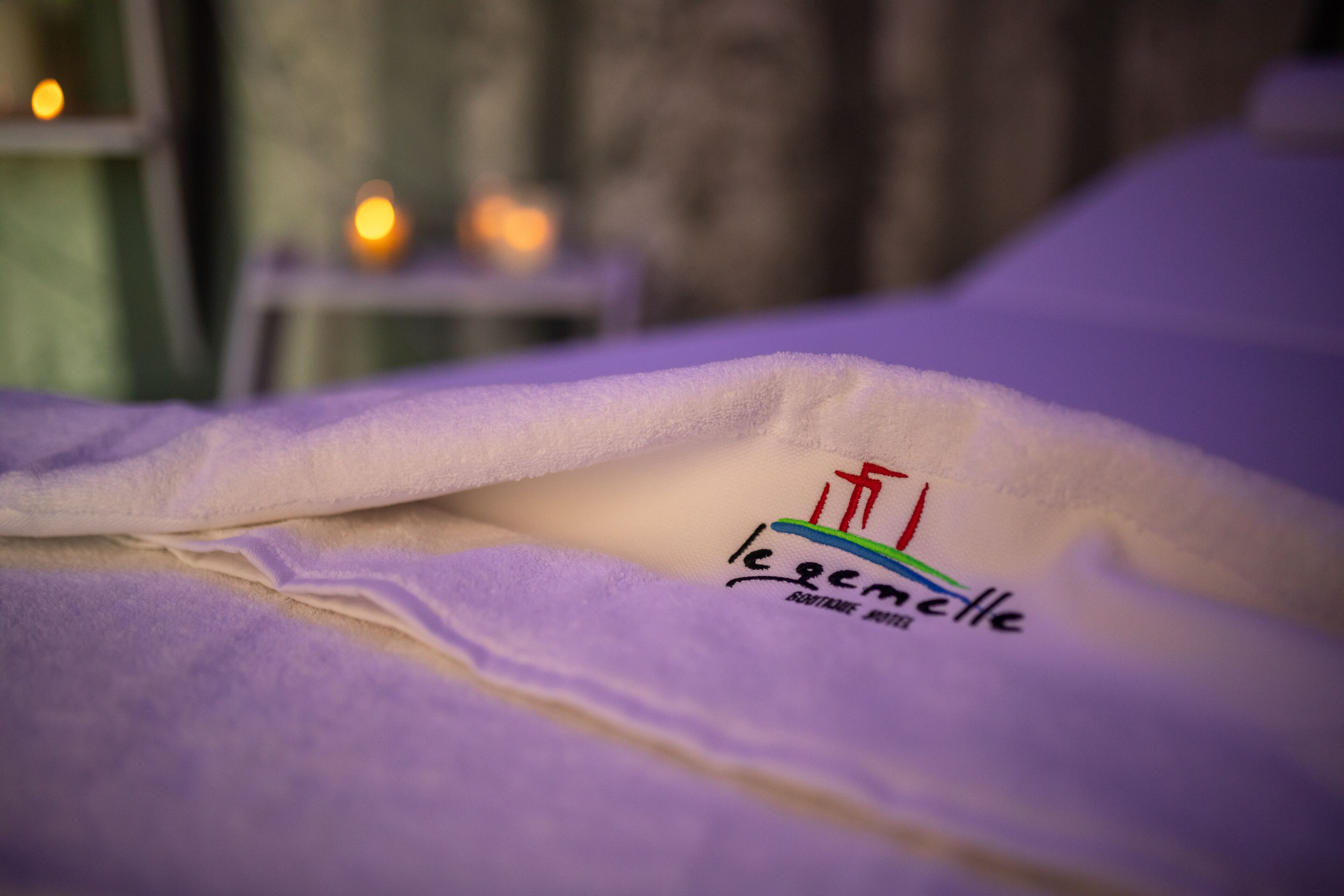Una cama con un edredón que cubre parcialmente un logotipo que dice "le grand cadre".