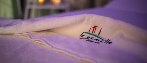 Una cama con un edredón que cubre parcialmente un logotipo que dice "le grand cadre".