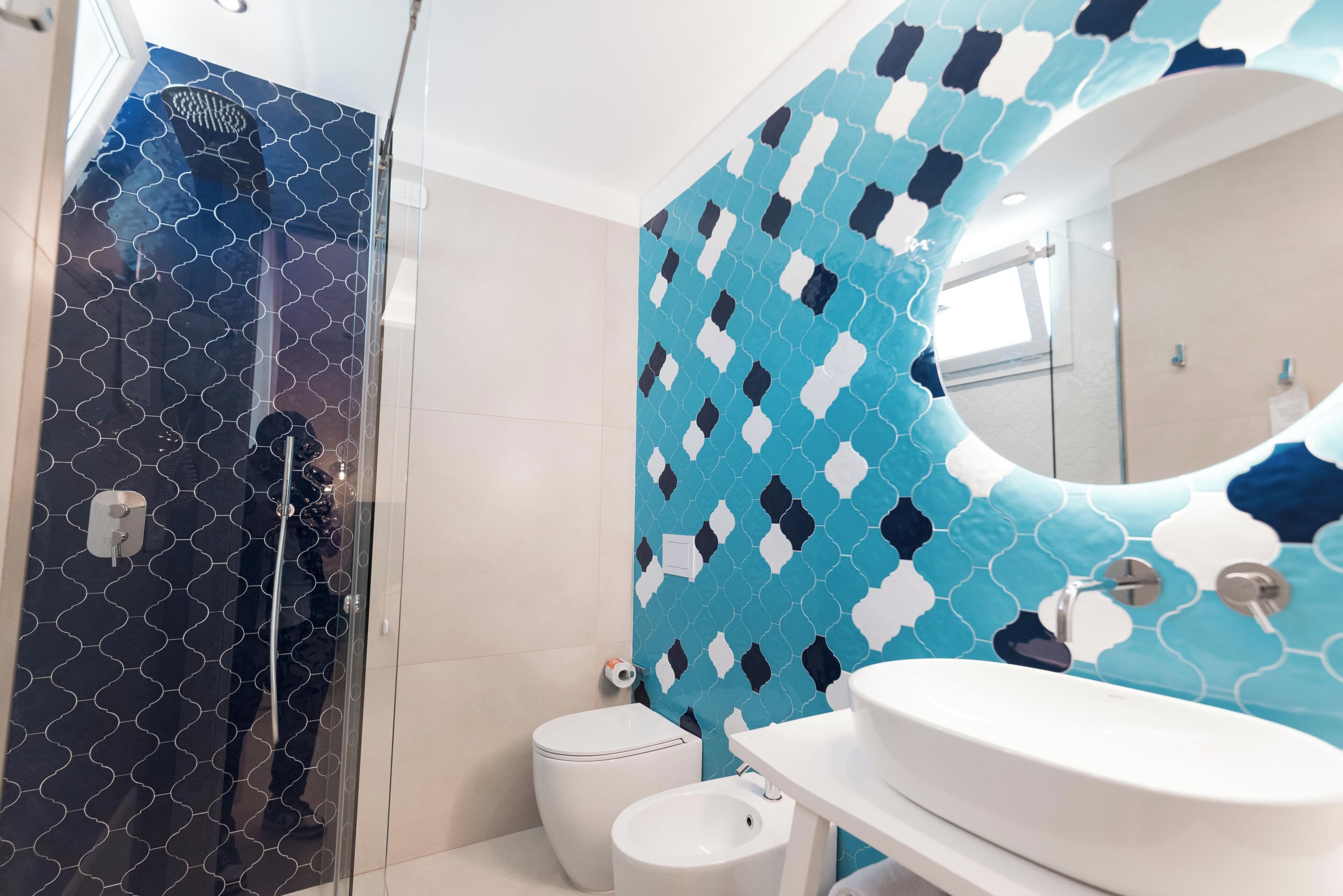 Une salle de bain équipée d’une douche, de toilettes, d’un bidet et d’un lavabo.