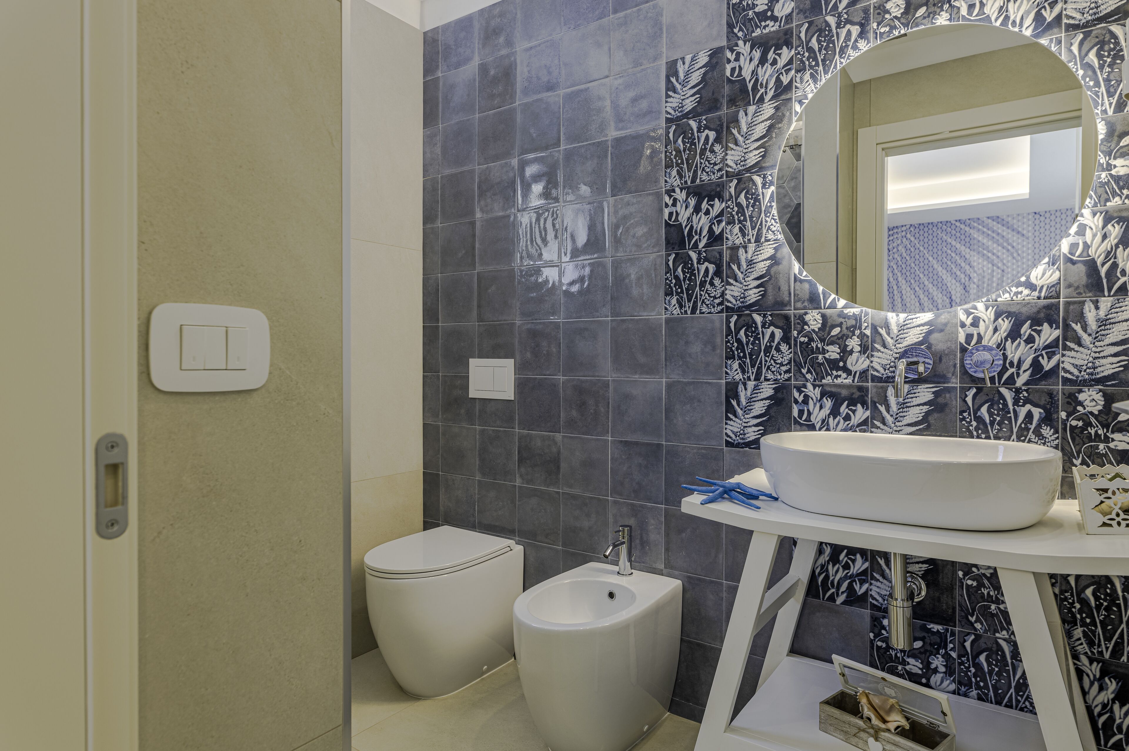 Ein Badezimmer mit Toilette, Bidet und Waschbecken mit Spiegel darüber.