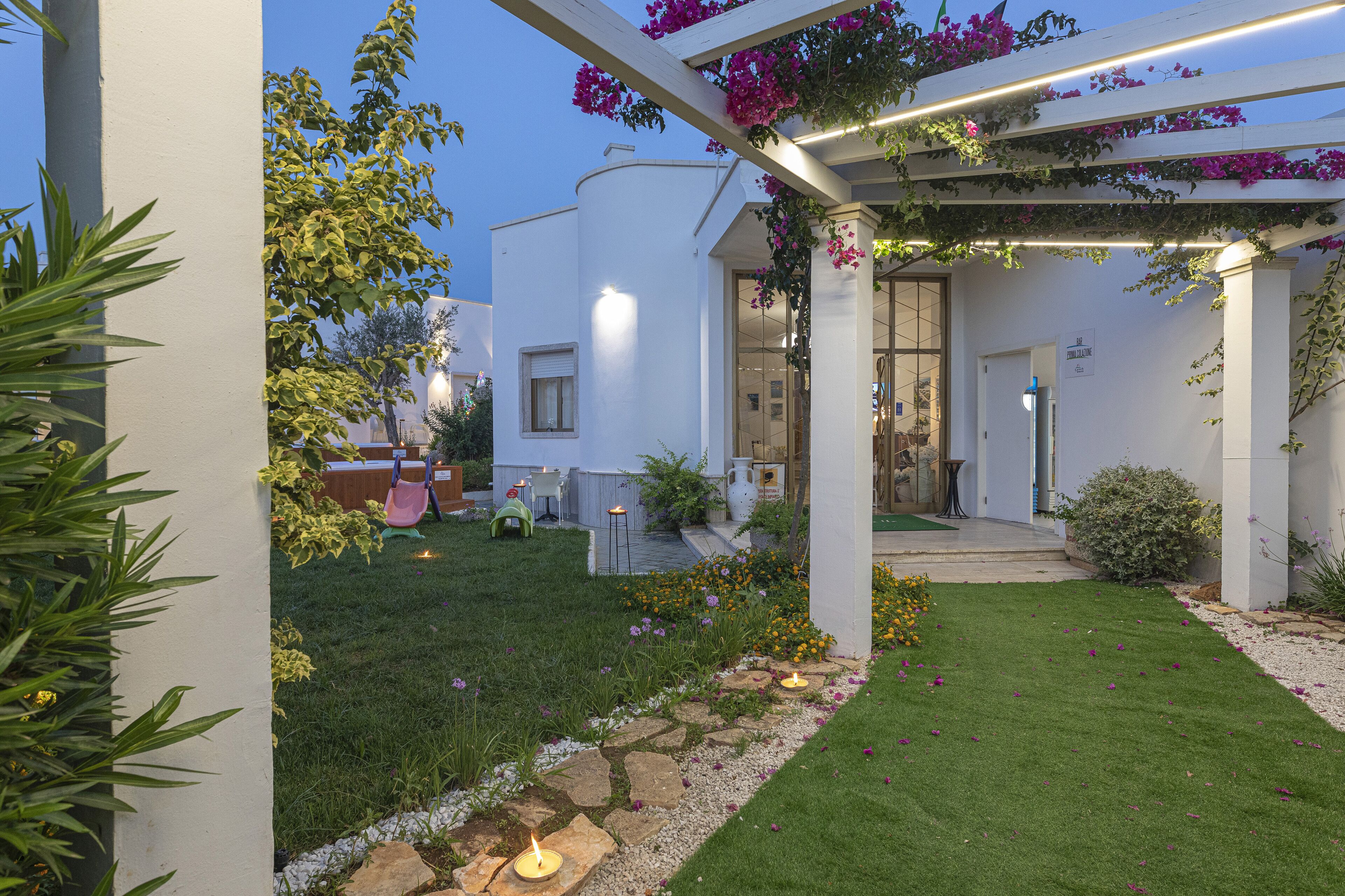A well-maintained garden with a pergola, stone pathway, and outdoor seating area.