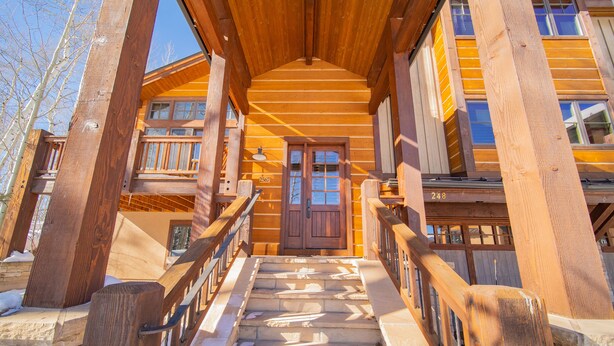 A wooden staircase leading to a wooden door with a number plate. - Keystone Sanctuary 248 by SummitCove Vacation Lodging (Keystone)
