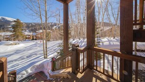 A wooden deck with a view of a snowy landscape and trees. - Keystone Sanctuary 248 by SummitCove Vacation Lodging (Keystone)