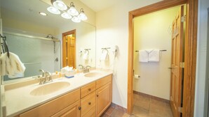 Un baño con dos lavamanos, un espejo grande y una puerta de madera.