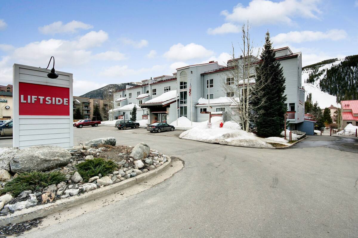 A residential area with a sign reading "LIFTSIDE" and a row of houses with a snowy landscape in the background.