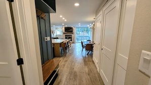 A hallway leading to a dining area with a kitchen and a TV mounted on the wall. - Liftside 14B (Keystone)