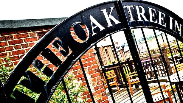 A black metal gate with the inscription "THE OAK TREE INN" in white capital letters. - Oak Tree Inn (Stanley)