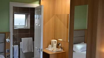 Un baño de hotel con ducha, inodoro y lavamanos.