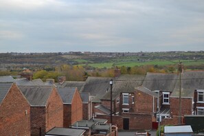 Un barrio residencial con casas de ladrillo, una vista despejada del campo circundante y un pueblo lejano.
