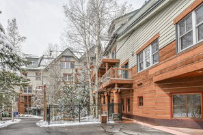 A residential building with a wooden facade, multiple windows, and a gated entrance. - Jack Pine 8008 by SummitCove Vacation Lodging (Keystone)