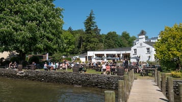 Ein Flussrestaurant mit Außenbestuhlung und einer Holzsteganlage.