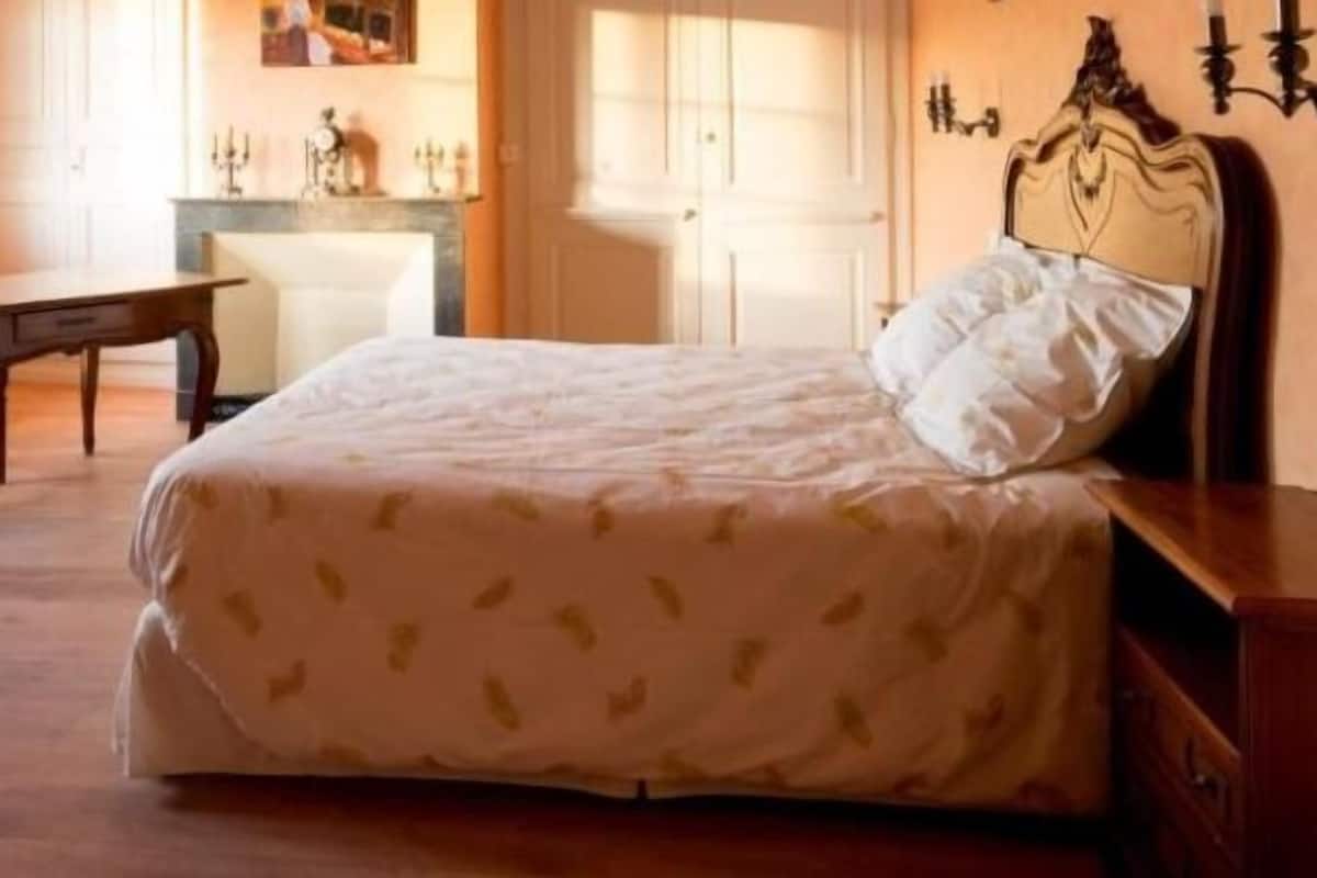 Un dormitorio con una cama, un aparador y una mesita de noche.