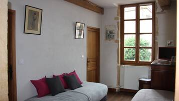 A room with a bed, a wooden door, a window, and a radiator.