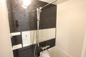 A modern bathroom with a shower, a mirror, and a sink. - SEKAI HOTEL Momiji (Osaka)