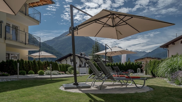 A patio with outdoor seating, a mountain backdrop, and a clear sky. - Residenz Allegra (Soelden)