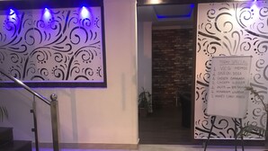 A modern interior with a staircase, decorative wall panels, and a menu board listing today's specials. - Hotel Triund Heights (Dharamshala)