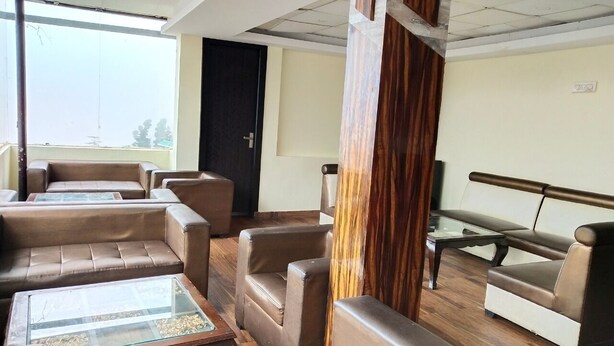 A modern lounge area with leather sofas and a glass coffee table. - Hotel Triund Heights (Dharamshala)