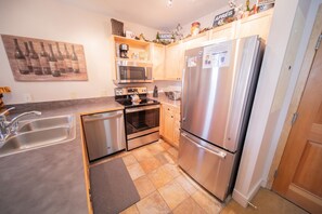 A modern kitchen with stainless steel appliances, a dishwasher, and a microwave.