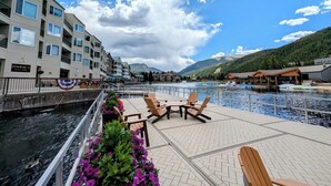 Une terrasse au bord de l’eau, avec des sièges extérieurs et une vue sur une rivière.