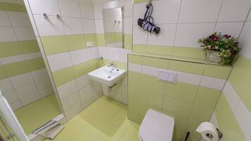 A bathroom with a sink, toilet, and shower.