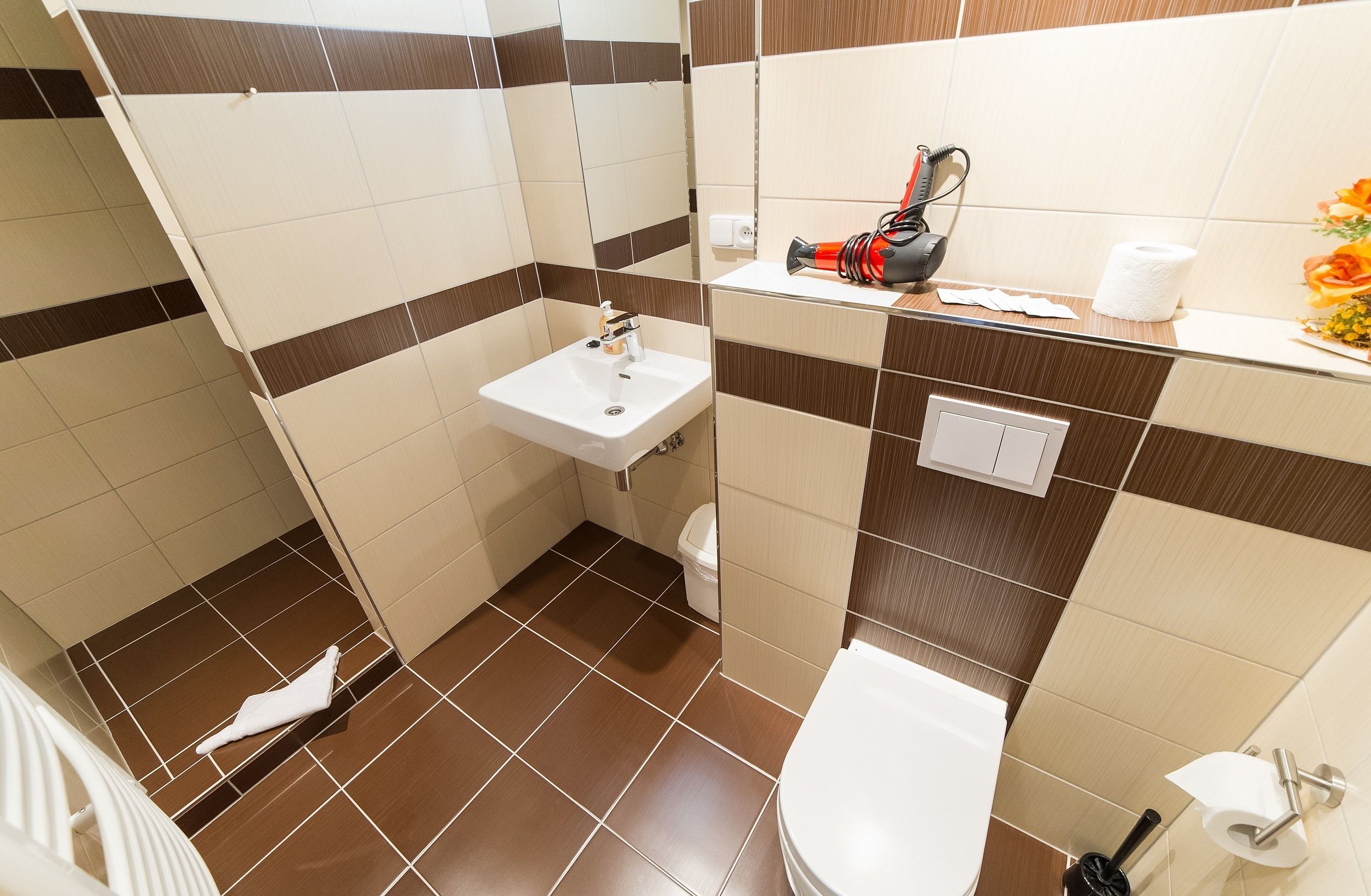 A bathroom with a sink, toilet, and mirror.